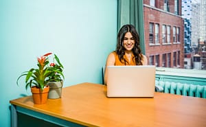 Image of woman smiling at website on laptop